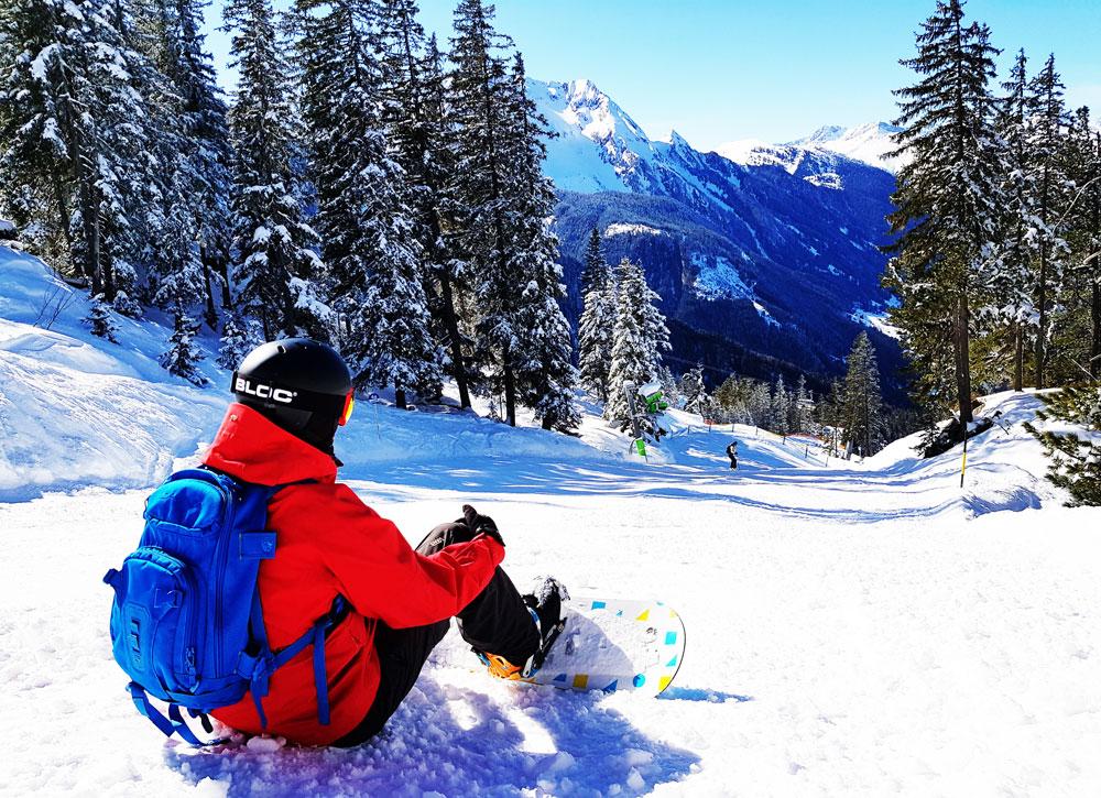 Mayrhofen Snowboarder sat by the trees